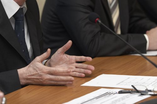 man sitting with attorney at a table being deposed - what to expect at a deposition concept