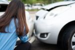 Women drivers sad after a car accident because not have car accident insurance.